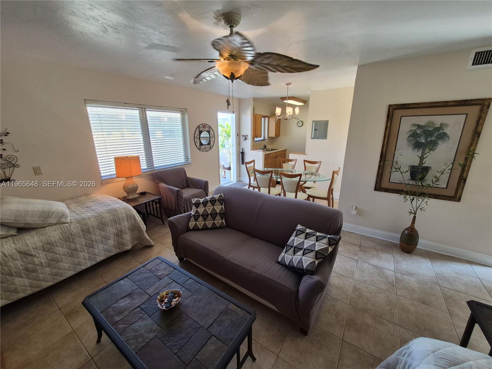 A living room with tile floors, a sofa, a bed, and an adjacent dining area — 520 Euclid Ave # 8, Miami Beach FL 33139, MIAMI BEACH, FL