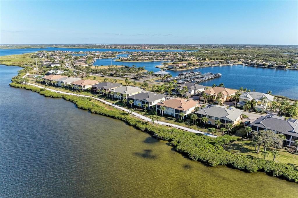 An aerial view shows three waterfront houses with tile roofs and palm trees — 1246 RIVERSCAPE STREET, BRADENTON, FL