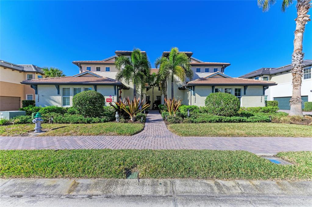 A living room features a sectional sofa, wood coffee table, and sliding doors overlooking water — 1246 RIVERSCAPE STREET, BRADENTON, FL