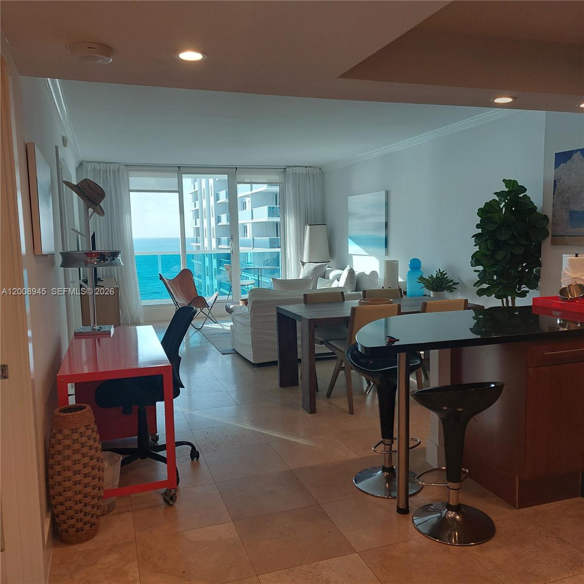 An open-concept living and dining area features tile floors, a kitchen island, and ocean views — 2301 Collins Ave # 1125, Miami Beach FL 33139, MIAMI BEACH, FL