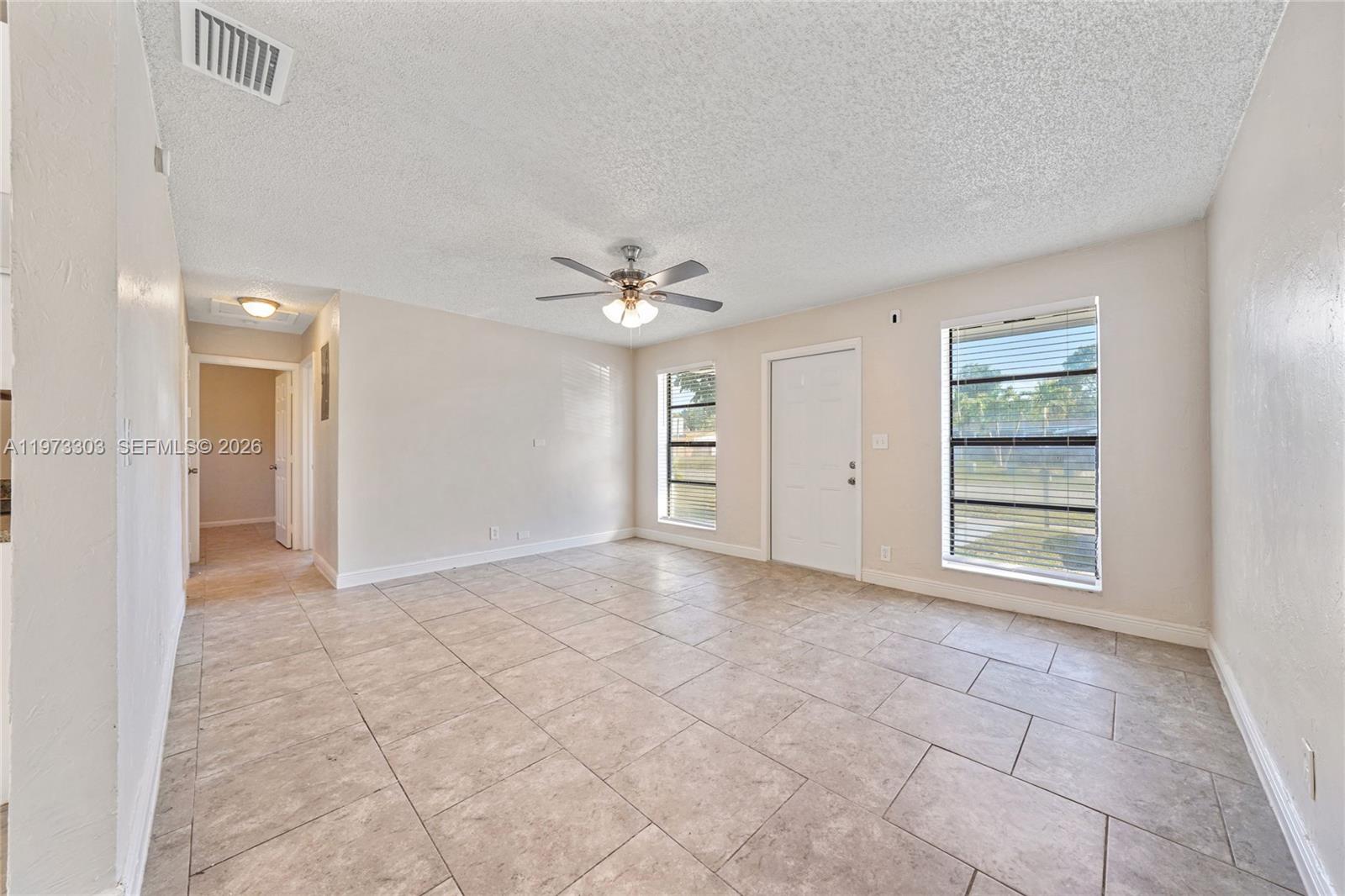 A living room features beige tile flooring, a ceiling fan, and two windows — 4721 NW 12th St, Lauderhill FL 33313, LAUDERHILL, FL