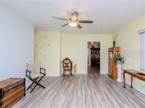 A room with light-colored walls, wood-look flooring, a ceiling fan, and a wooden chair — 5617 GULFPORT BOULEVARD S, GULFPORT, FL