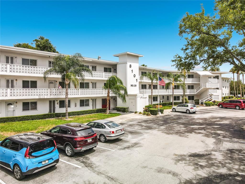 A multi-story apartment building with a parking lot and several cars in front — 8101 113TH STREET UNIT 309, SEMINOLE, FL