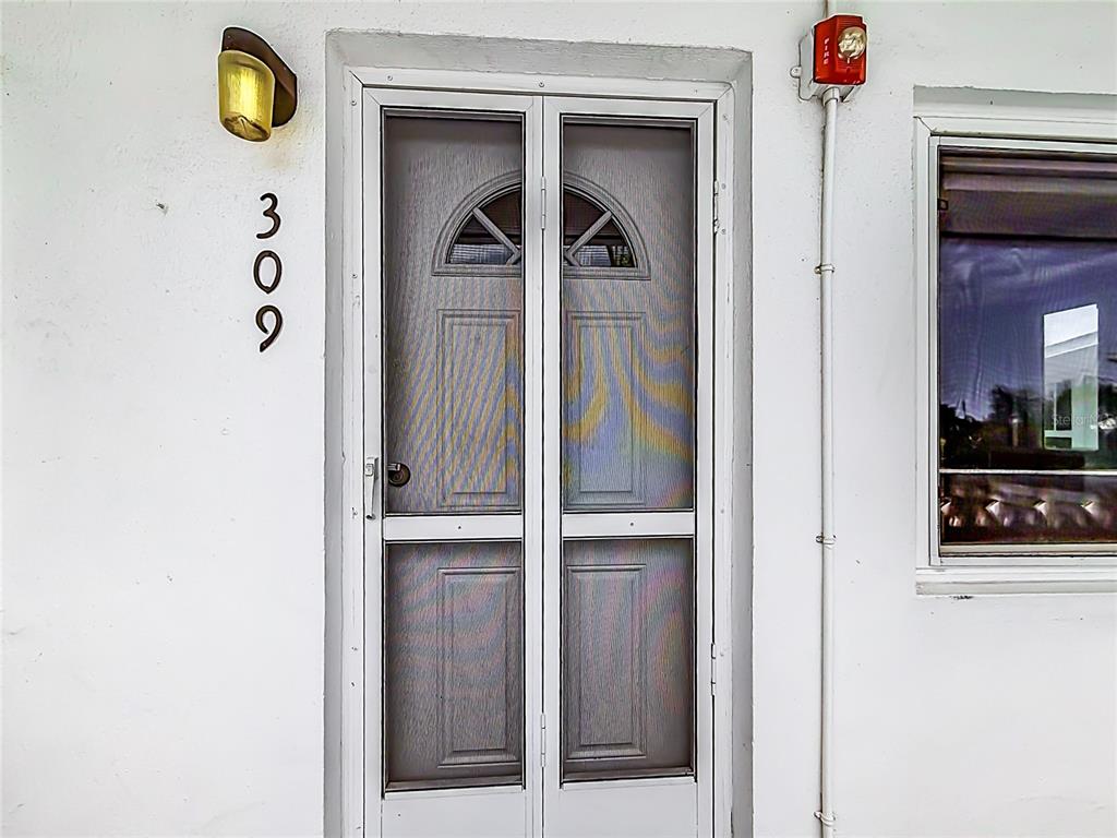 A white exterior door with a screen and the number 309 mounted on the wall — 8101 113TH STREET UNIT 309, SEMINOLE, FL