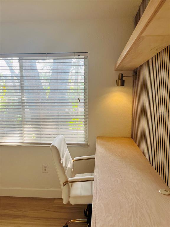 A home office features a built-in wooden desk, a white chair, and a slatted wall — 3914 W NEPTUNE STREET UNIT 27, TAMPA, FL