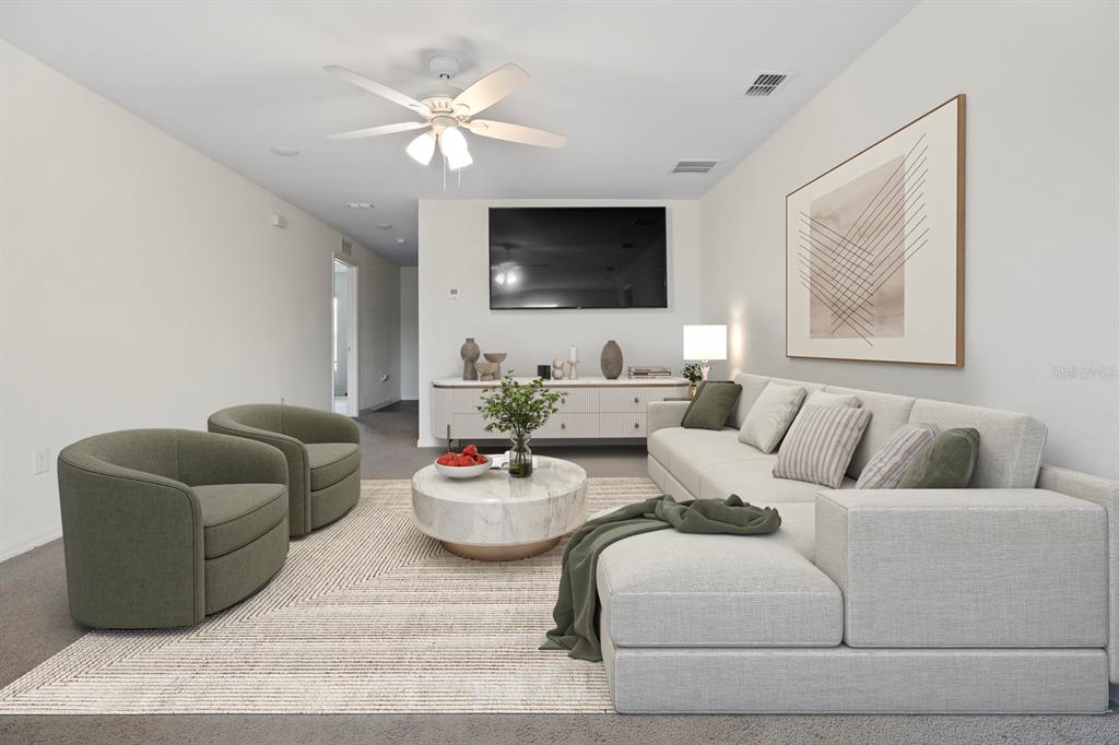 A living room features a sectional sofa, two green armchairs, a coffee table, and television — 27 MAGNOLIA BLOSSOM LANE, KISSIMMEE, FL
