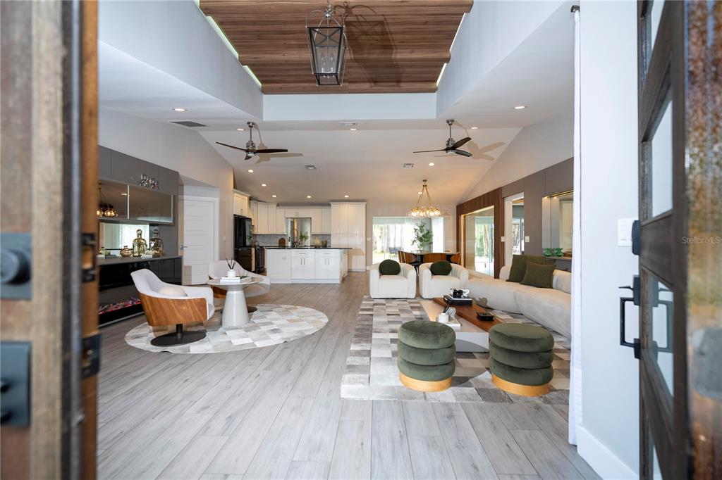 A paved walkway leads to the double front doors of a white house with landscaping — 10129 LONE TREE LANE, ORLANDO, FL