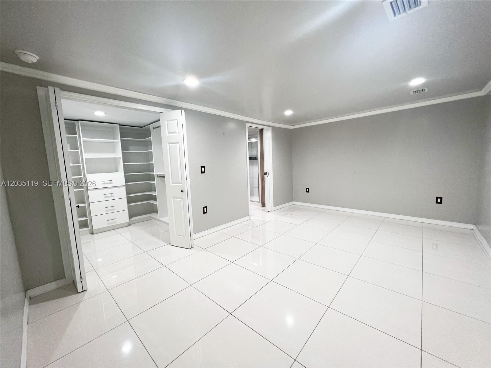 A room with white tile floors, gray walls, recessed lighting, and an open walk-in closet — 9615 NW 3rd Ave, Miami FL 33150, MIAMI, FL