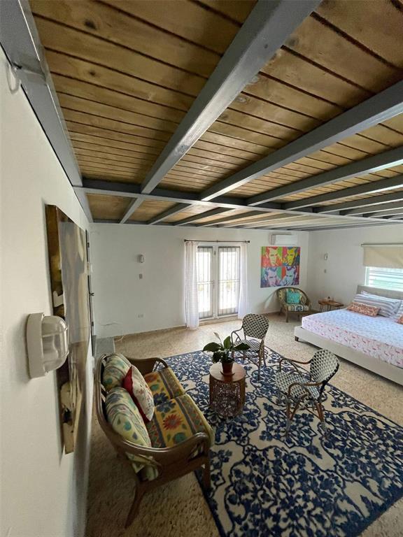 A bedroom with a patterned rug, seating area, and exposed wooden ceiling beams — 681 N KM 11.7 ISLOTE, ARECIBO, PR