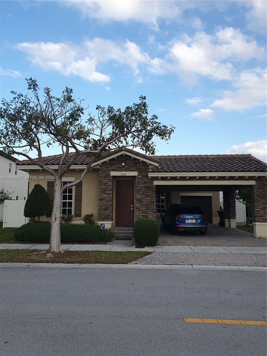 A single-story house with a stone facade, a tiled roof, and an attached carport — 9171 SW 169th PL # 0, Miami FL 33196, MIAMI, FL