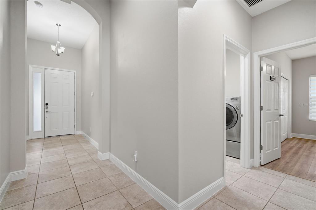 A tiled entryway leads to a front door, a laundry room, and a hallway — 7316 HERMES COURT, APOLLO BEACH, FL