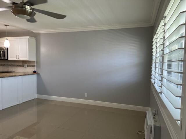 A dining area with gray walls, tile floors, white cabinetry, and plantation shutters on the windows — 800 W Horizons W # 211, Boynton Beach FL 33435, BOYNTON BEACH, FL