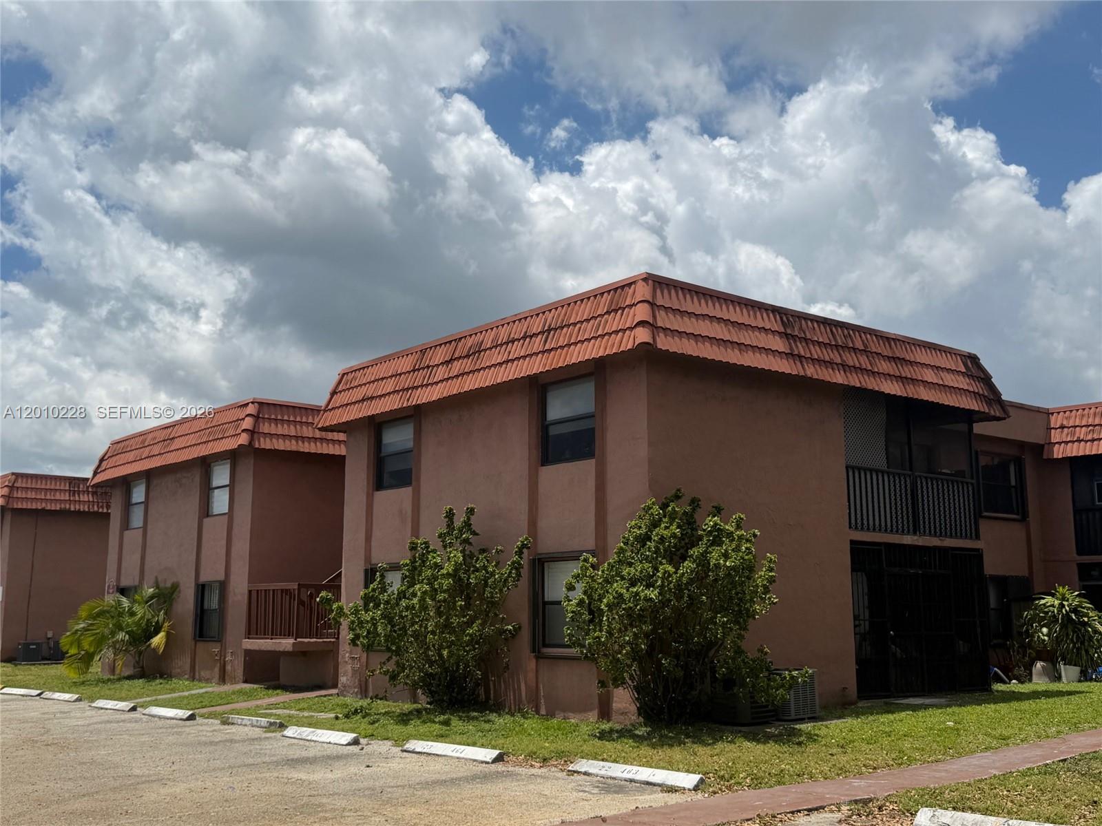 The exterior of a two-story brown apartment building with a red tiled roof — 6540 W 27th Ct # 24, Hialeah FL 33016, HIALEAH, FL