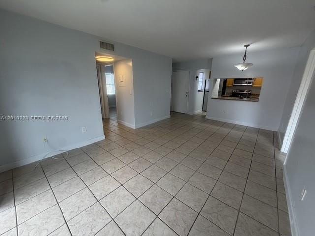 An open-concept living area features light gray walls, beige tile flooring, and a kitchen pass-through — 6540 W 27th Ct # 24, Hialeah FL 33016, HIALEAH, FL