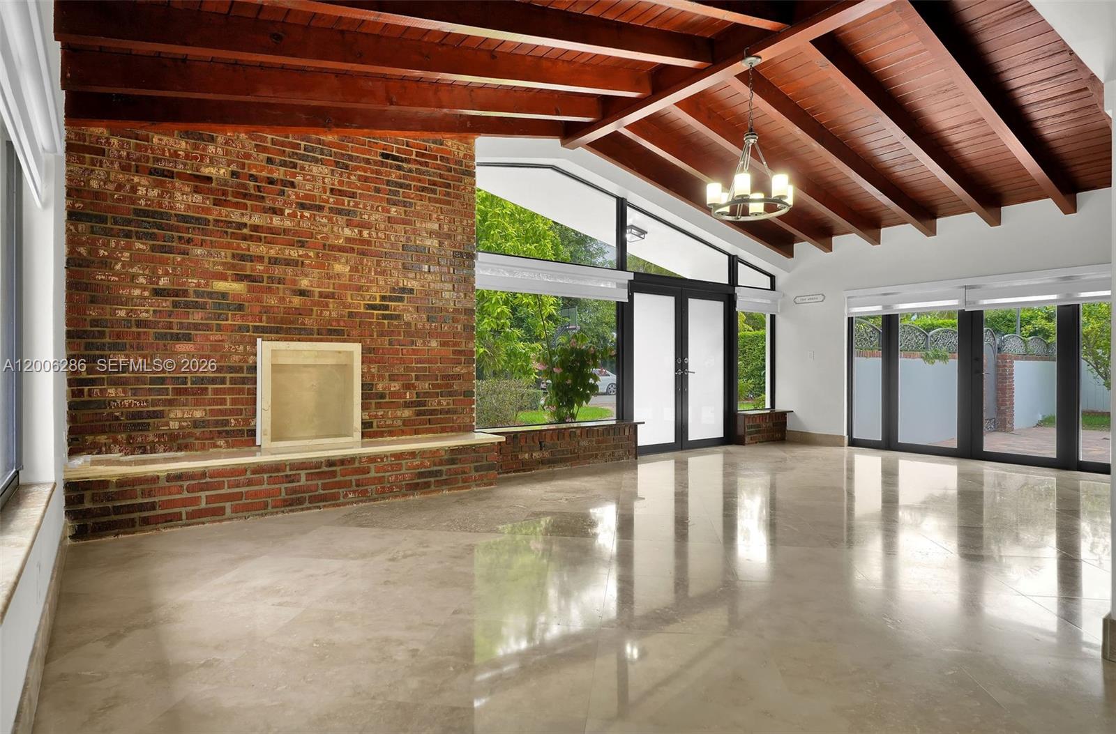 A living room features a brick fireplace, vaulted wood-beamed ceilings, and large glass doors — 6820 SW 86th Ave, Miami FL 33143, MIAMI, FL