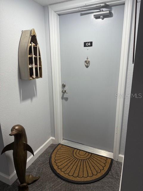 A gray door labeled 104 features a door knocker, a closer, and a decorative boat shelf — 25188 MARION AVENUE UNIT D104, PUNTA GORDA, FL