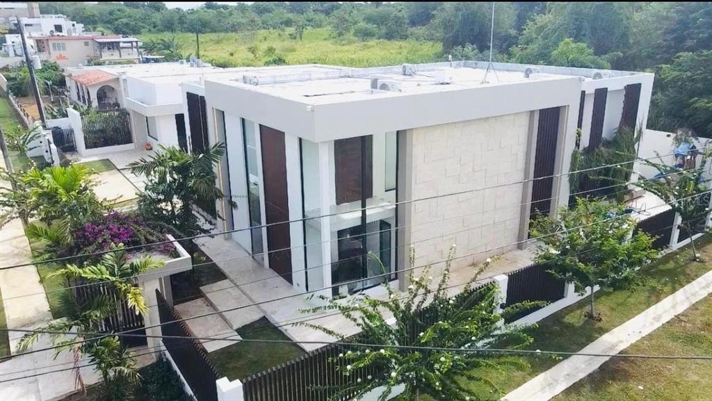 An aerial view of a modern two-story house with stone cladding and a flat roof — Bo Hato Arriba 492, ARECIBO, PR