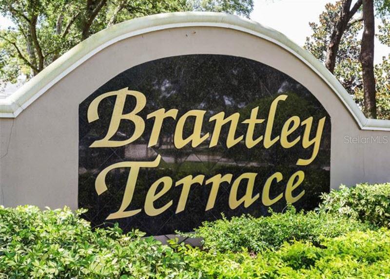 A curved stone monument sign displays the name Brantley Terrace in gold lettering — 588 BRANTLEY TERRACE WAY UNIT 305, ALTAMONTE SPRINGS, FL