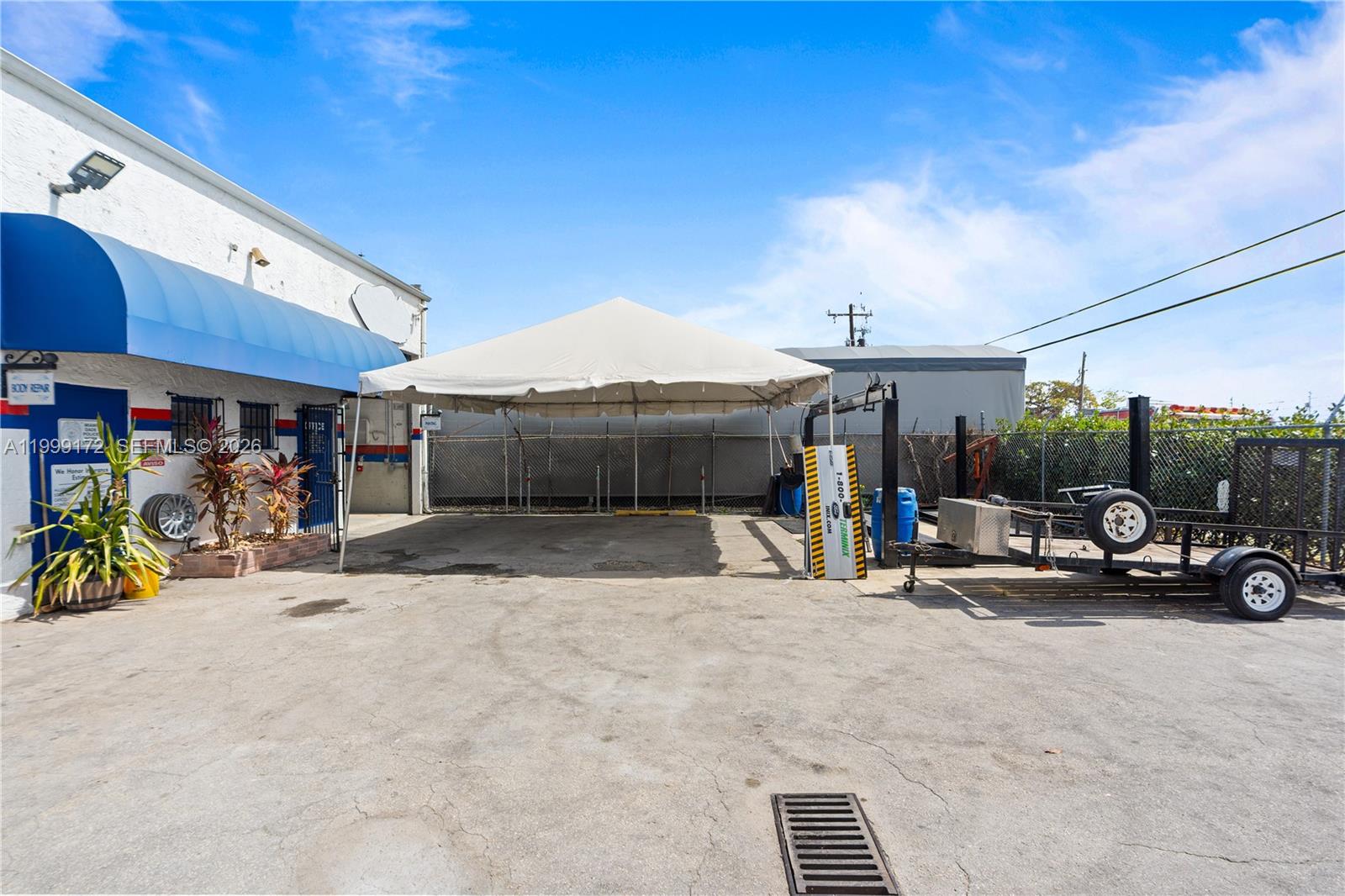 An exterior view of a commercial building with a blue awning and a white canopy — 10501 SW 185th Ter, Cutler Bay FL 33157, CUTLER BAY, FL