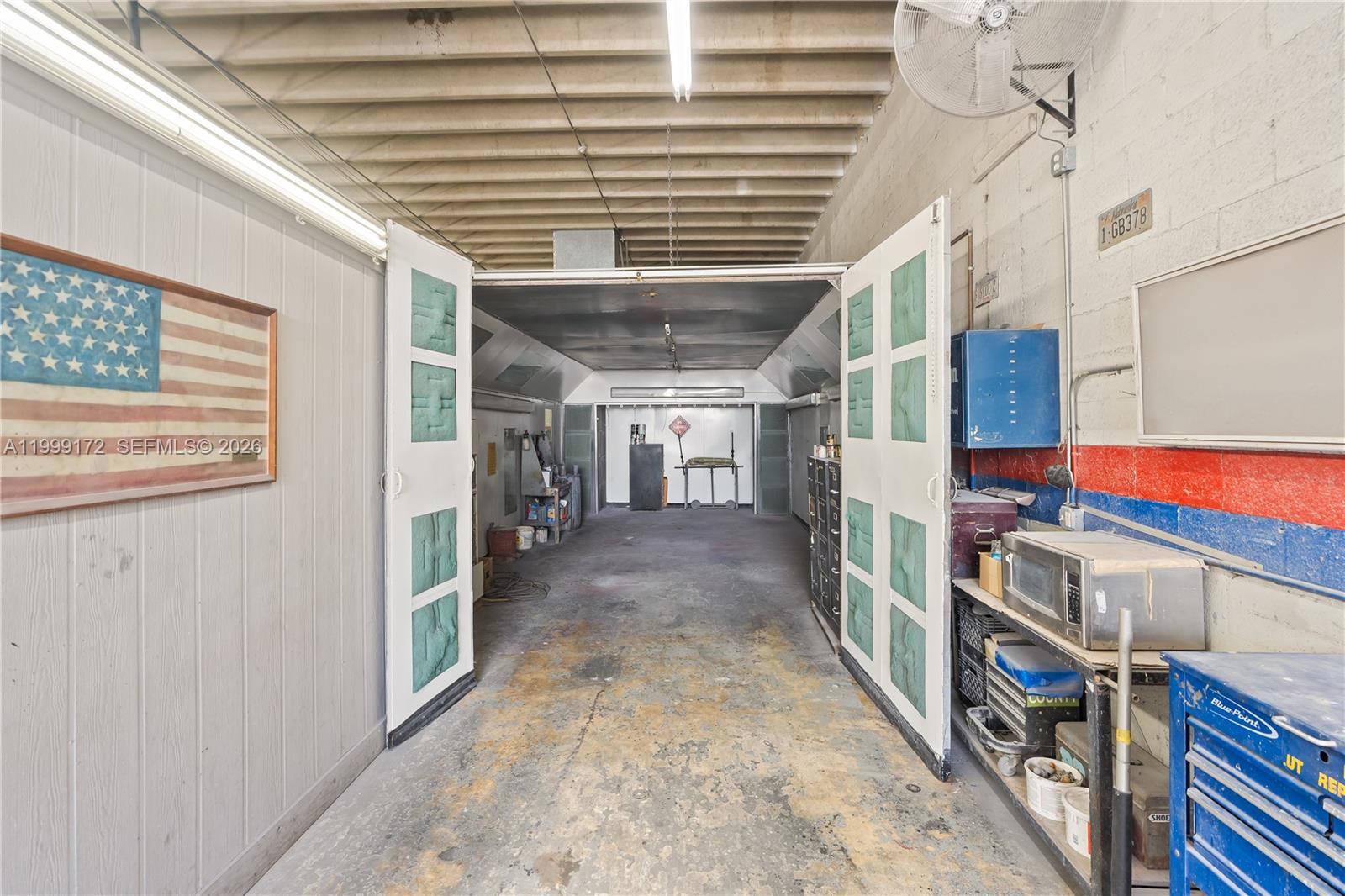 This industrial workspace features a paint booth with large doors and concrete flooring — 10501 SW 185th Ter, Cutler Bay FL 33157, CUTLER BAY, FL