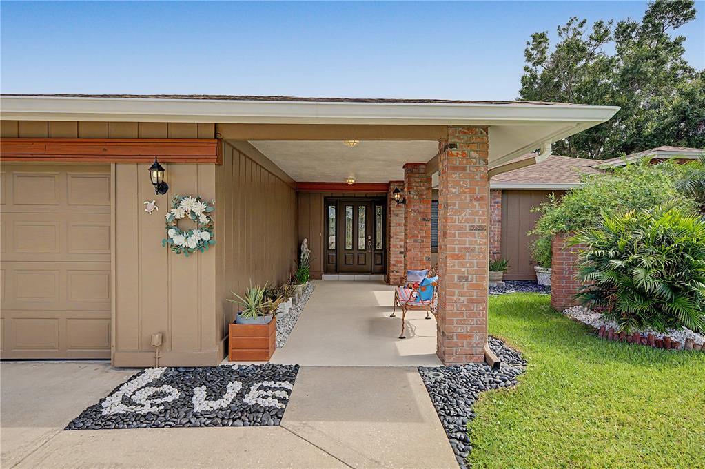 A house exterior features a covered entryway with a brick column and a concrete walkway — 450 CYPRESS CREEK CIRCLE, OLDSMAR, FL