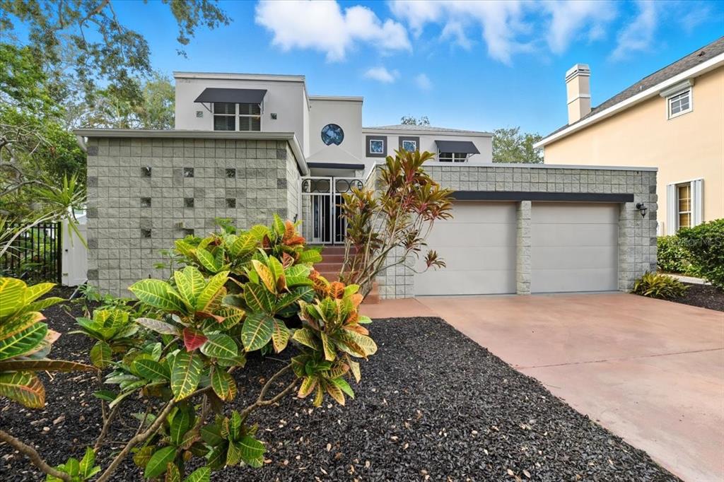 A two-story house with a concrete block facade, two-car garage, and a landscaped front yard — 2713 CHAMBRAY LANE, TAMPA, FL