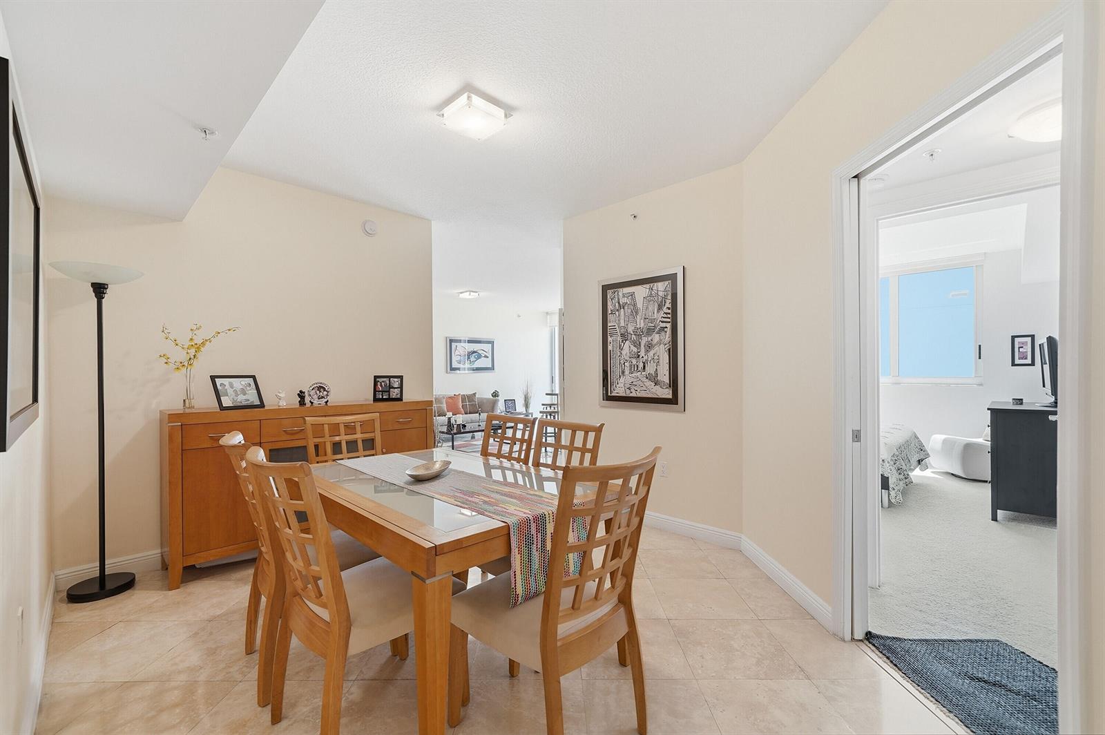 A dining room with a wooden table and chairs, tile flooring, and a sideboard — 1755 E Hallandale Beach Boulevard # 207e, Hallandale Beach FL 33009, HALLANDALE BEACH, FL