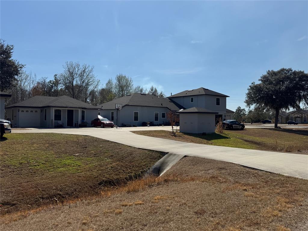 A large gray house with a concrete driveway and a small detached shed — 3792 DUNWICH AVENUE, ORLANDO, FL