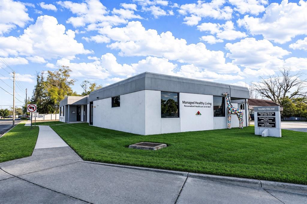 A single-story commercial building with a white exterior, a giraffe statue, and a signage monument — 4804 EDGEWATER DRIVE, ORLANDO, FL
