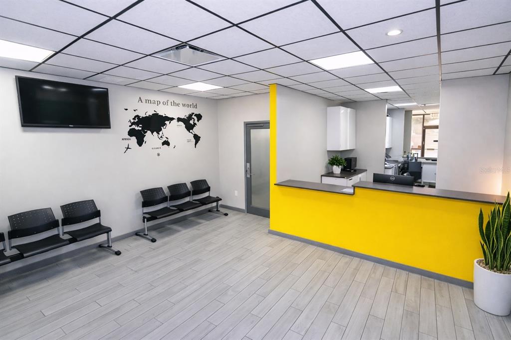 A waiting room features a yellow reception desk, black chairs, and a world map wall decal — 4804 EDGEWATER DRIVE, ORLANDO, FL