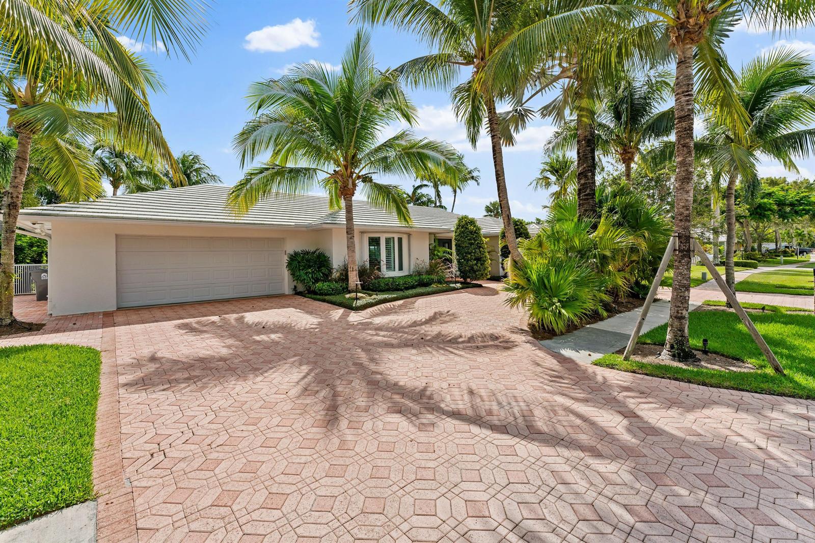 A single-story house with a paved driveway, palm trees, and a two-car garage — 18150 Perigon Way, Jupiter FL 33458, JUPITER, FL