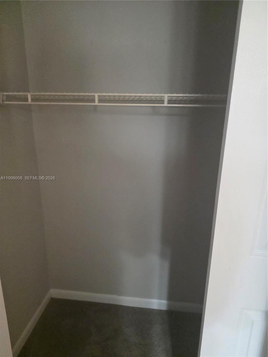 A small closet features gray walls, gray carpeting, and a single white wire shelf — 9500 SW 3rd St # 259, Boca Raton FL 33428, BOCA RATON, FL