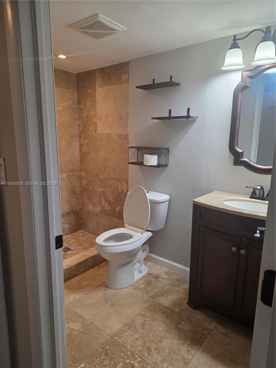 A bathroom features a tiled walk-in shower, a toilet, and a dark wood vanity — 9500 SW 3rd St # 259, Boca Raton FL 33428, BOCA RATON, FL