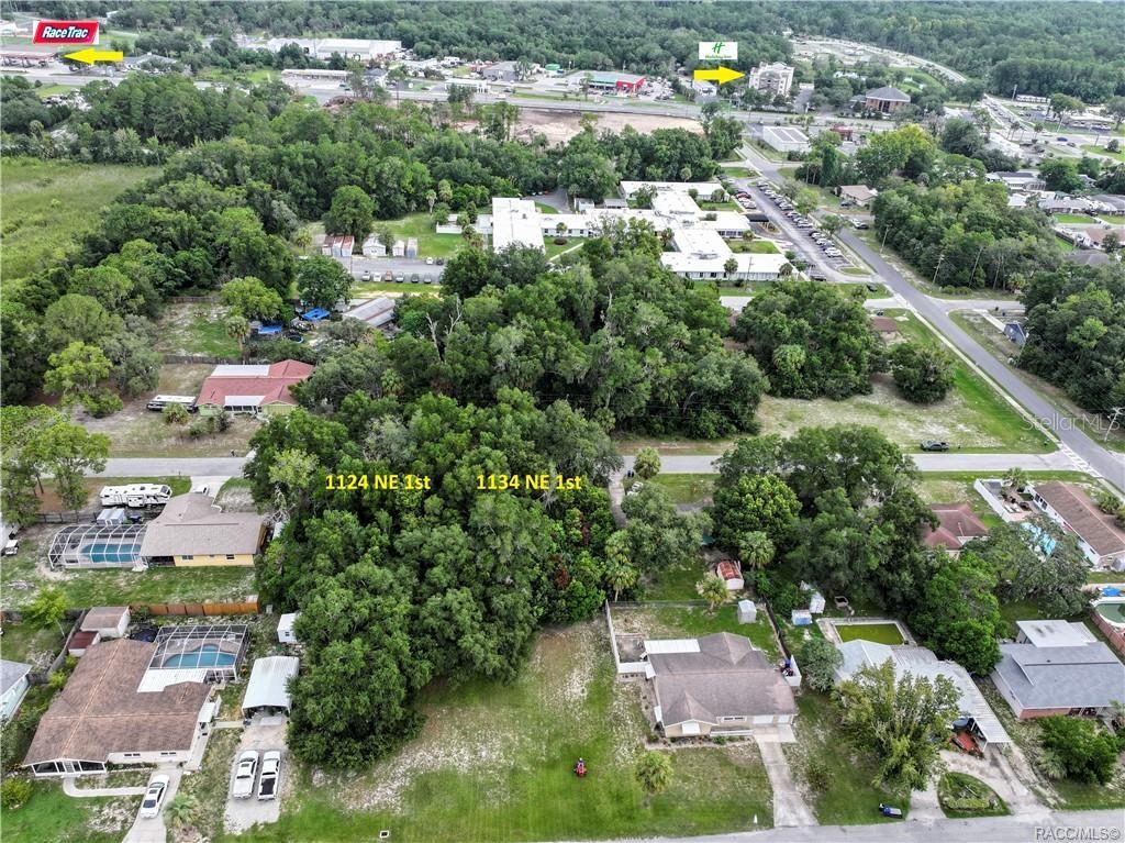 This aerial view shows two adjacent residential lots with mature trees and surrounding houses — 1124 NE 1ST TERRACE, CRYSTAL RIVER, FL
