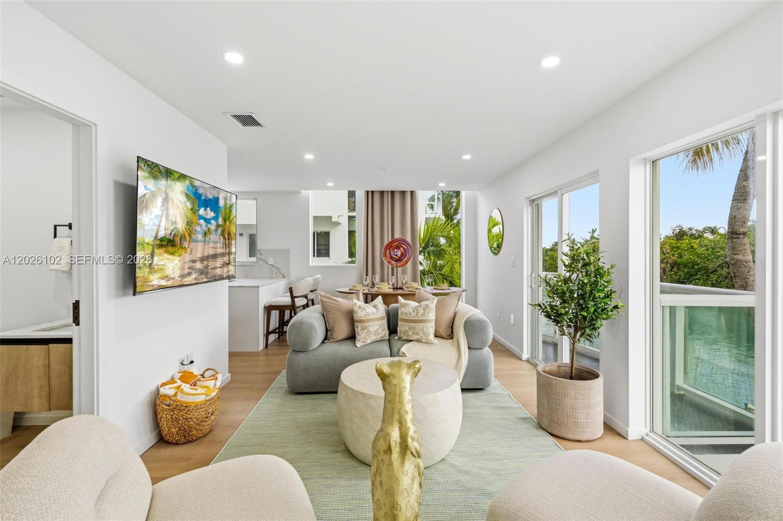 A bright living room features a gray sofa, round coffee table, and a balcony view — 1975 Calais Dr # 5, Miami Beach FL 33141, MIAMI BEACH, FL
