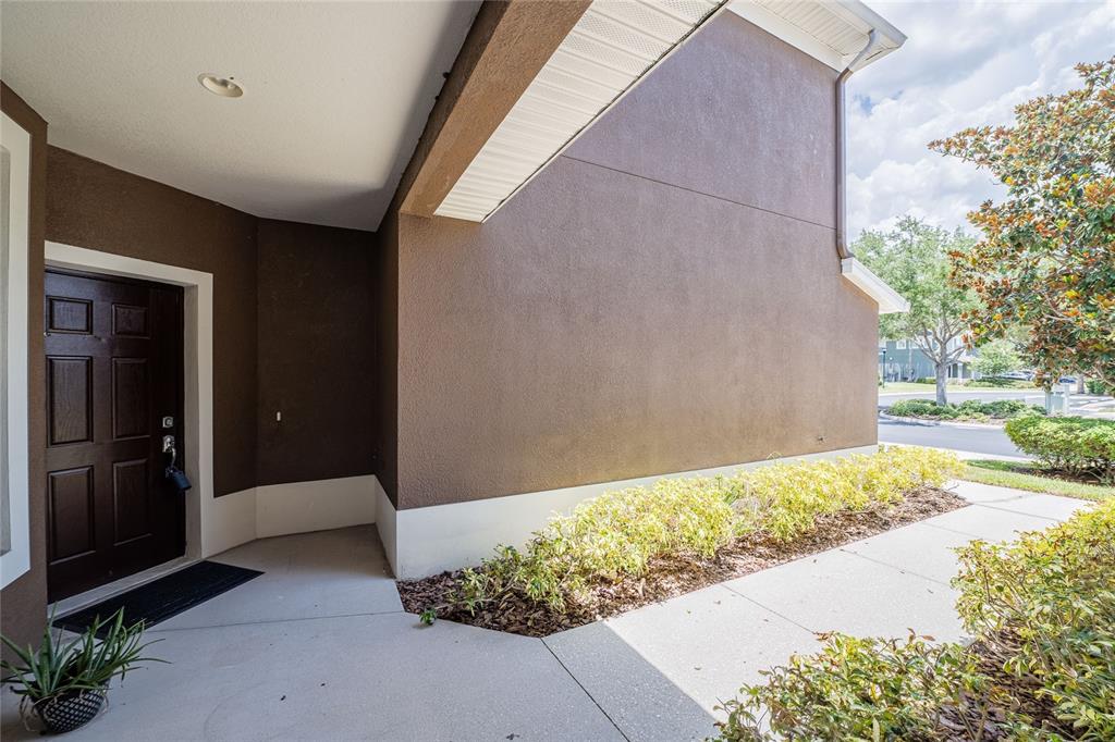 A brown stucco house exterior features a dark front door and a concrete walkway — 2242 KINGS PALACE DRIVE UNIT 2242, RIVERVIEW, FL