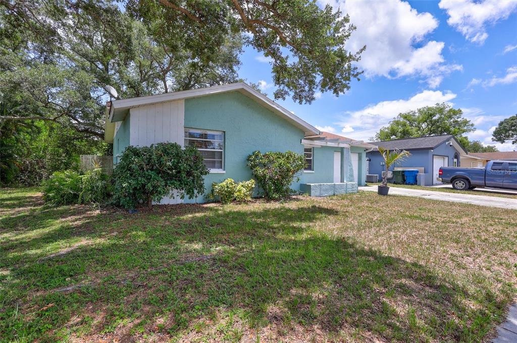 A teal single-story house with a white accent wall and a detached garage — 504 7TH STREET SE, LARGO, FL