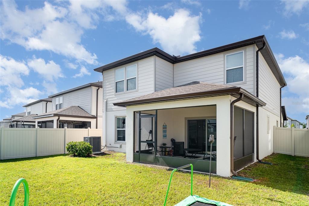 The exterior of a two-story house features a screened-in back patio and a fenced yard — 465 WATERFORD DRIVE, LAKE ALFRED, FL