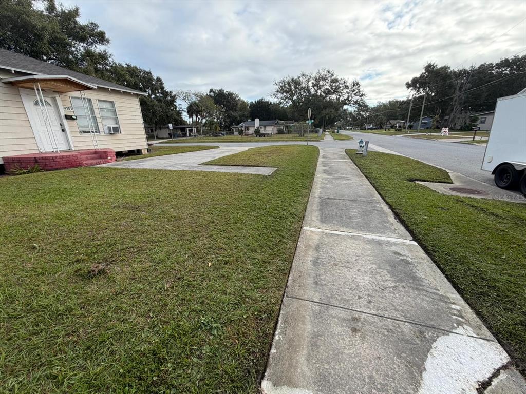 A view of a house exterior with a concrete driveway, sidewalk, and front lawn — 4201 CEPEDA STREET, ORLANDO, FL