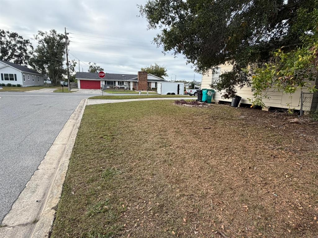 A view of a residential yard with a house, a stop sign, and trees — 4201 CEPEDA STREET, ORLANDO, FL
