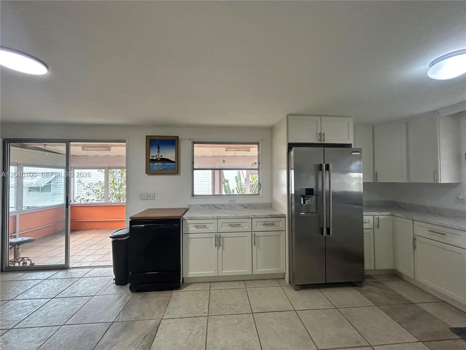 A kitchen features white cabinets, stainless steel appliances, and a sliding door to a patio — 2341 SW 84th Ave, Davie FL 33324, DAVIE, FL