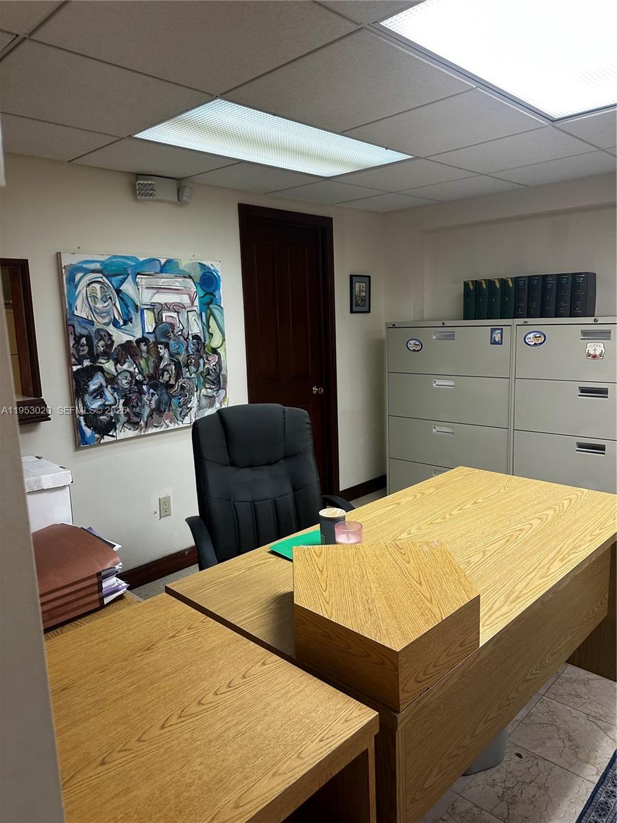 An office features a wooden desk, a black chair, filing cabinets, and abstract wall art — 1105 SW 87th Ave, Miami FL 33174, MIAMI, FL