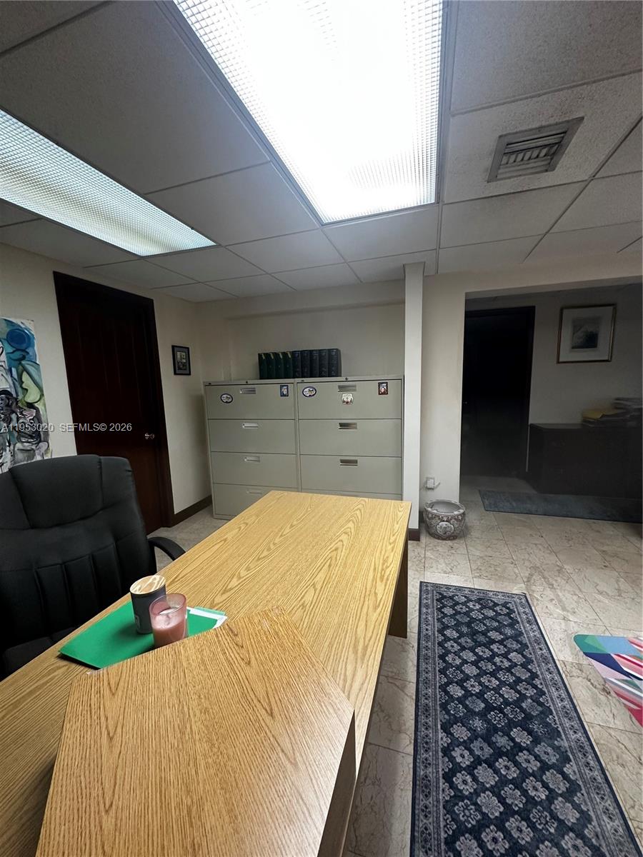 An office space features a wooden desk, filing cabinets, and a patterned area rug — 1105 SW 87th Ave, Miami FL 33174, MIAMI, FL