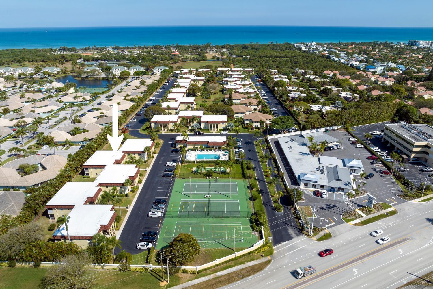 An aerial view shows a residential complex with tennis courts, a pool, and parking lots — 717 S Us Hwy 1 S # 118, Jupiter FL 33477, JUPITER, FL