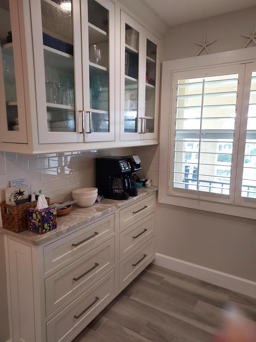 A kitchen coffee station features white cabinets, glass-front upper doors, and a stone countertop — 717 S Us Hwy 1 S # 118, Jupiter FL 33477, JUPITER, FL