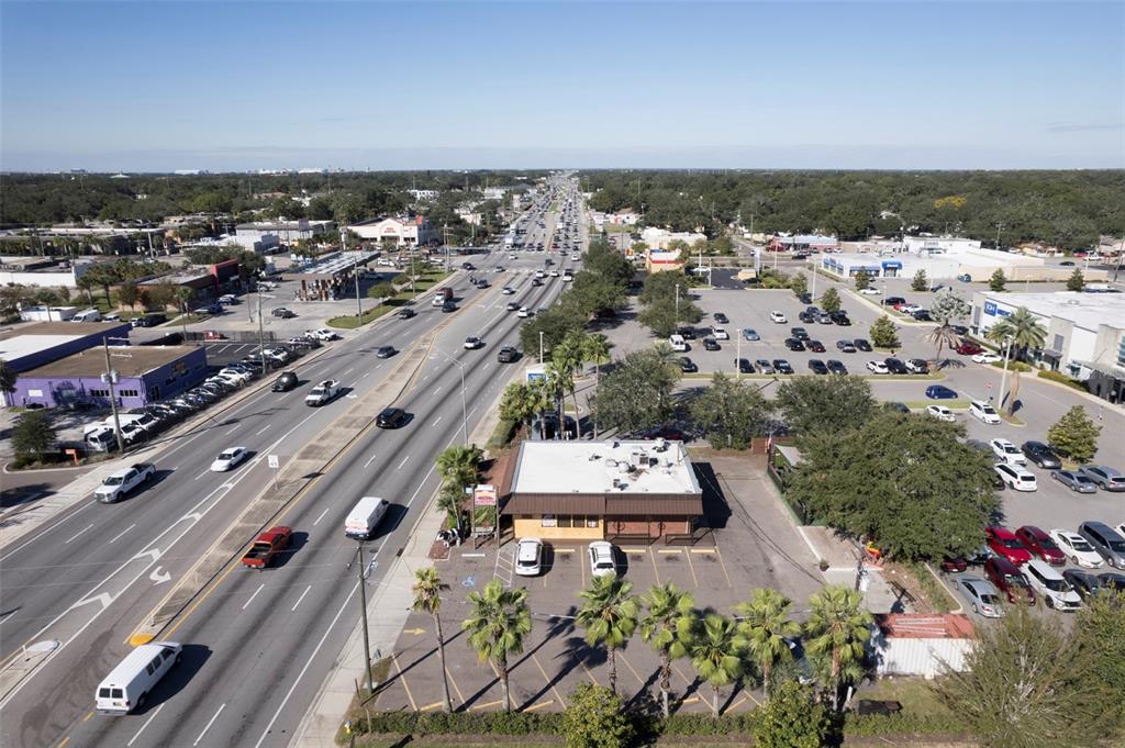An aerial view shows a commercial building with a parking lot next to a highway — 2311 W HILLSBOROUGH AVENUE, TAMPA, FL