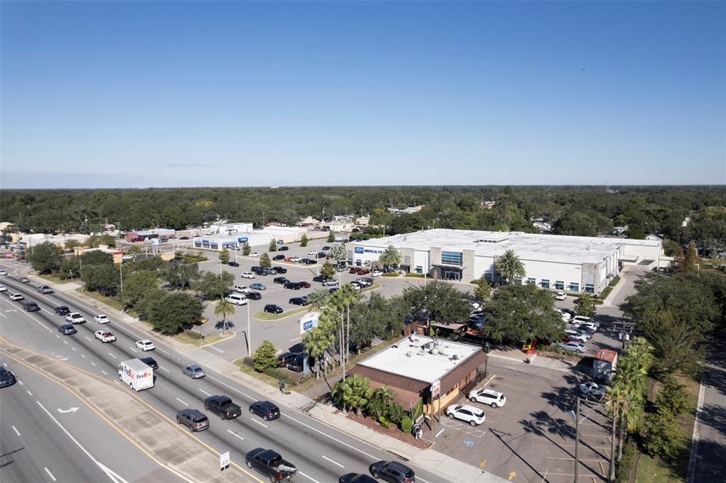 An aerial view shows a commercial plaza with parking lots and a busy road — 2311 W HILLSBOROUGH AVENUE, TAMPA, FL