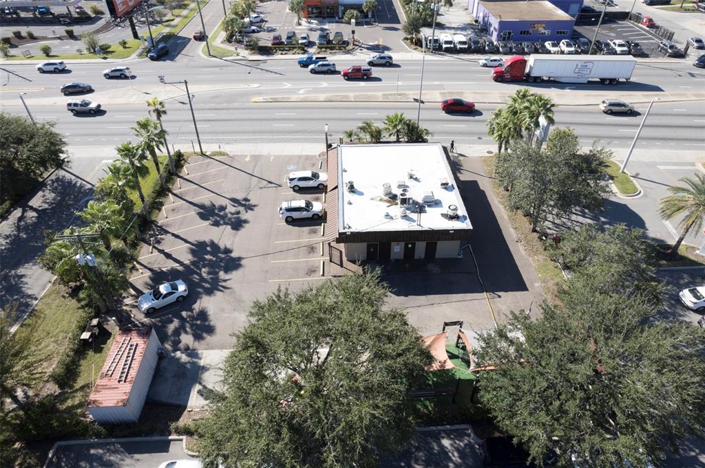 An aerial view shows a commercial building with a parking lot and surrounding trees — 2311 W HILLSBOROUGH AVENUE, TAMPA, FL
