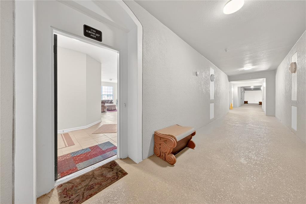 An open doorway leads from a textured hallway into a tiled apartment interior — 2788 ALMATON LOOP UNIT 404, KISSIMMEE, FL