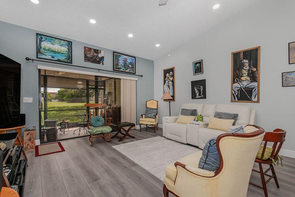 A living room features light gray flooring, a white sofa, and several framed wall paintings — 3459 Inverrary W # 3459, Lauderhill FL 33319, LAUDERHILL, FL